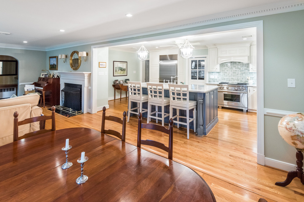 Kitchen - transitional light wood floor kitchen idea in Richmond with an island, raised-panel cabinets, quartzite countertops, green backsplash, subway tile backsplash, stainless steel appliances, a farmhouse sink and blue cabinets