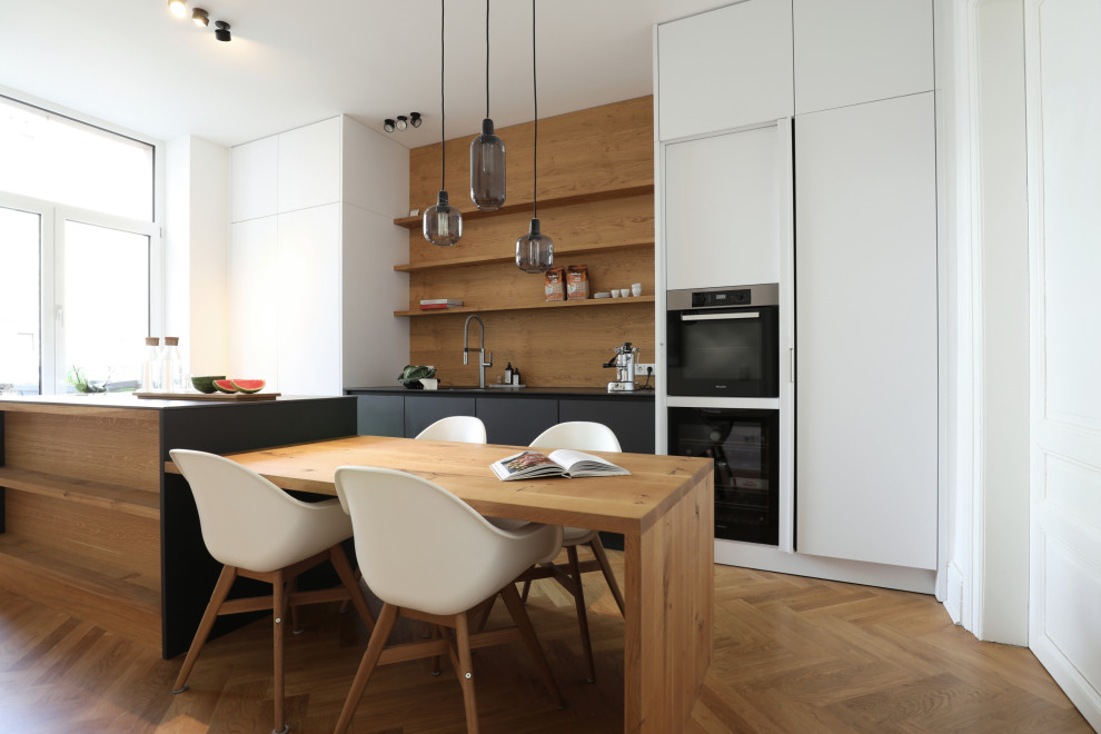 Zweizeilige, Große Moderne Küche mit Rückwand aus Holz und Kücheninsel in Frankfurt am Main