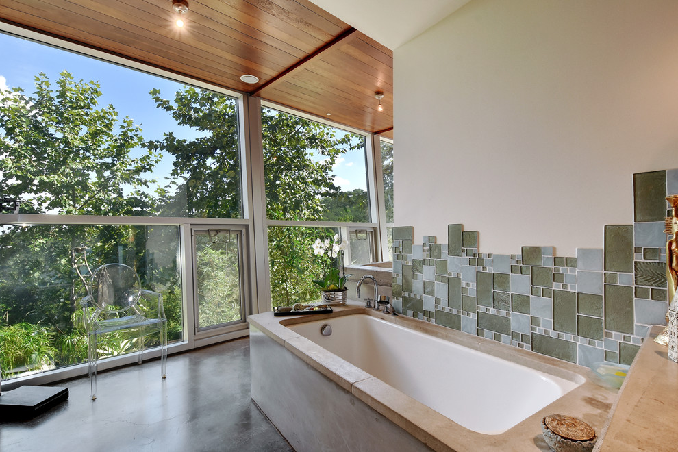 Design ideas for a contemporary master bathroom in Austin with an undermount tub, gray tile and glass tile.