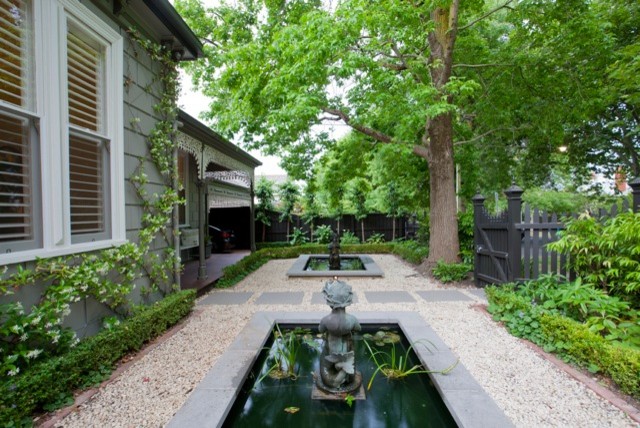 This is an example of a large traditional front yard partial sun formal garden in Melbourne with a water feature.