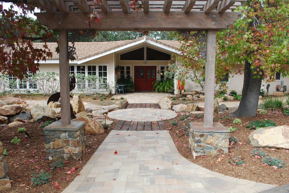 This is an example of a mid-sized transitional side yard full sun xeriscape in San Diego with a water feature and natural stone pavers.