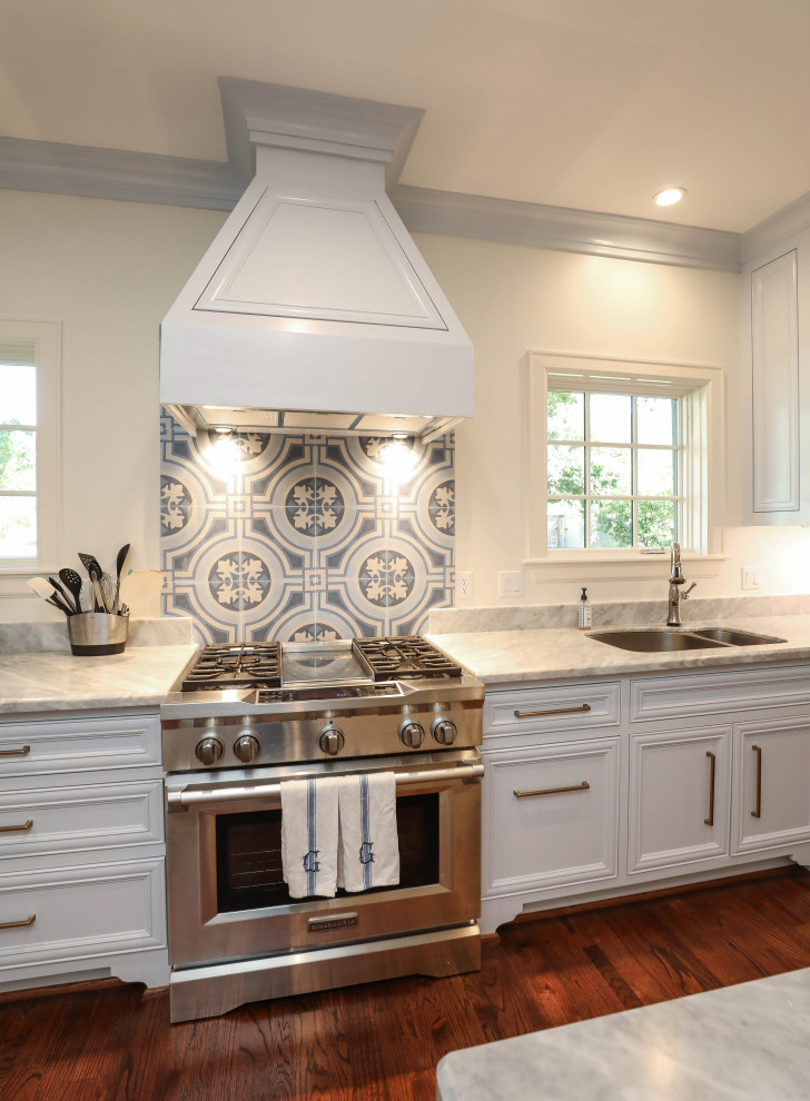 Photo of a country kitchen in Houston with white cabinets, marble benchtops, stainless steel appliances and with island.