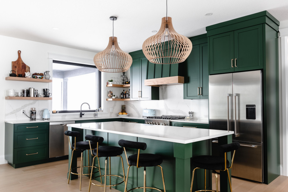 Inspiration for a mid-sized country l-shaped light wood floor and brown floor open concept kitchen remodel in Toronto with an undermount sink, shaker cabinets, green cabinets, quartz countertops, white backsplash, quartz backsplash, stainless steel appliances, an island and white countertops