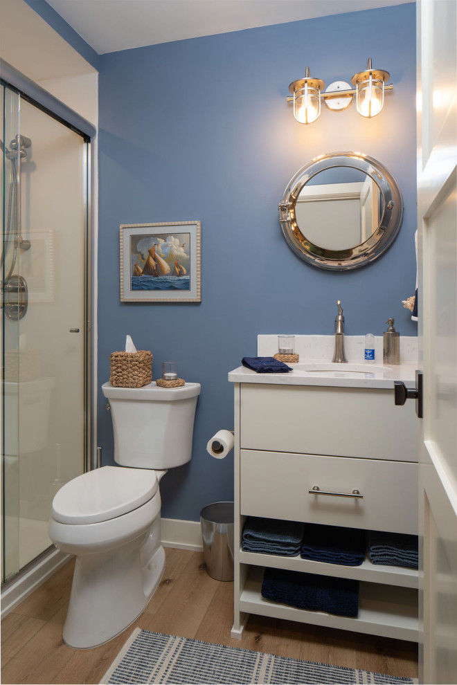 Example of a small 3/4 light wood floor, brown floor and single-sink sliding shower door design in Minneapolis with flat-panel cabinets, white cabinets, a one-piece toilet, white walls, an undermount sink, granite countertops, turquoise countertops and a freestanding vanity