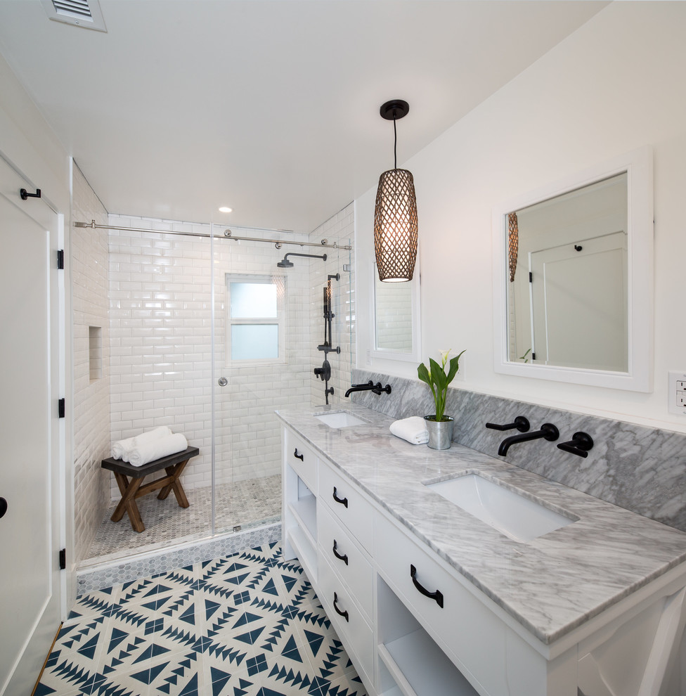 Inspiration for a mid-sized eclectic master bathroom in San Francisco with flat-panel cabinets, white cabinets, an alcove shower, a one-piece toilet, white tile, ceramic tile, white walls, light hardwood floors, an undermount sink, marble benchtops, a sliding shower screen and green floor.