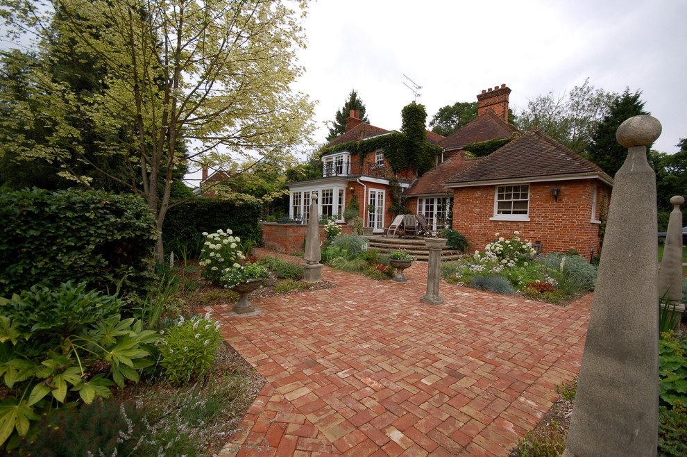 Photo of a large traditional backyard formal garden in Essex with brick pavers.