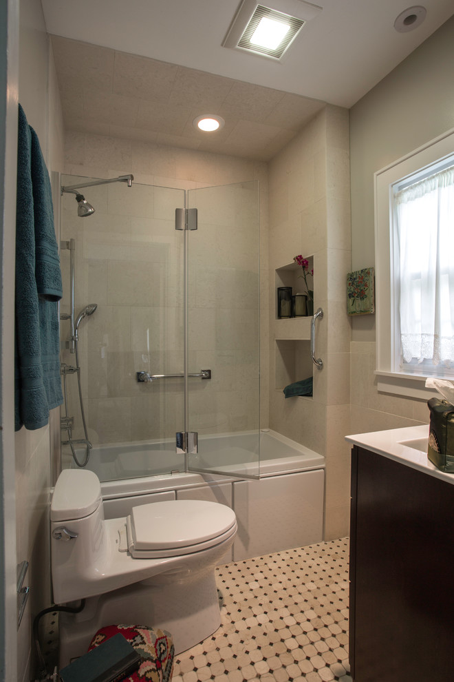 Small transitional master bathroom in Chicago with furniture-like cabinets, dark wood cabinets, an alcove tub, a shower/bathtub combo, a one-piece toilet, beige tile, limestone, beige walls, marble floors, an undermount sink, marble benchtops, beige floor and a hinged shower door.