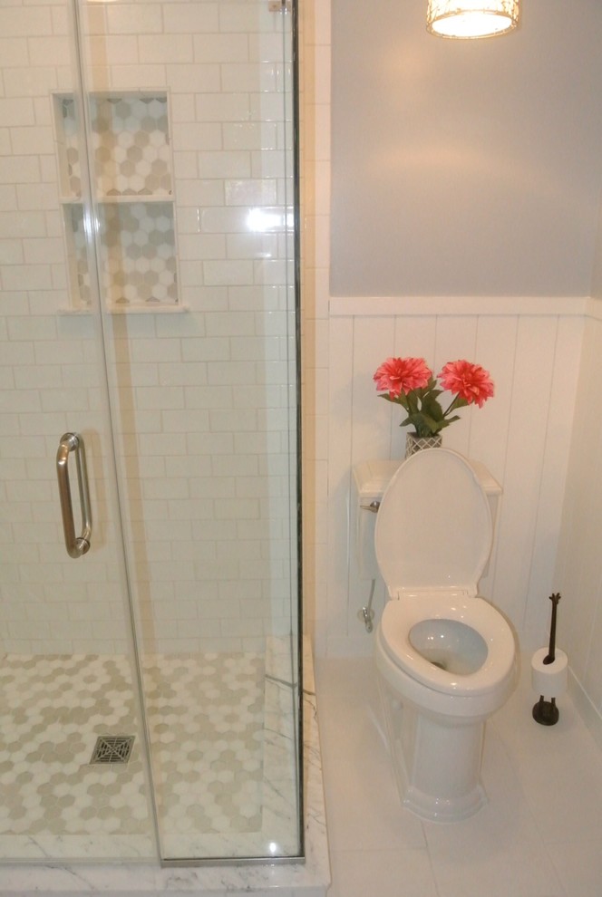 Inspiration for a mid-sized transitional master white tile and ceramic tile porcelain tile corner shower remodel with an undermount sink, recessed-panel cabinets, white cabinets, marble countertops, a one-piece toilet and gray walls