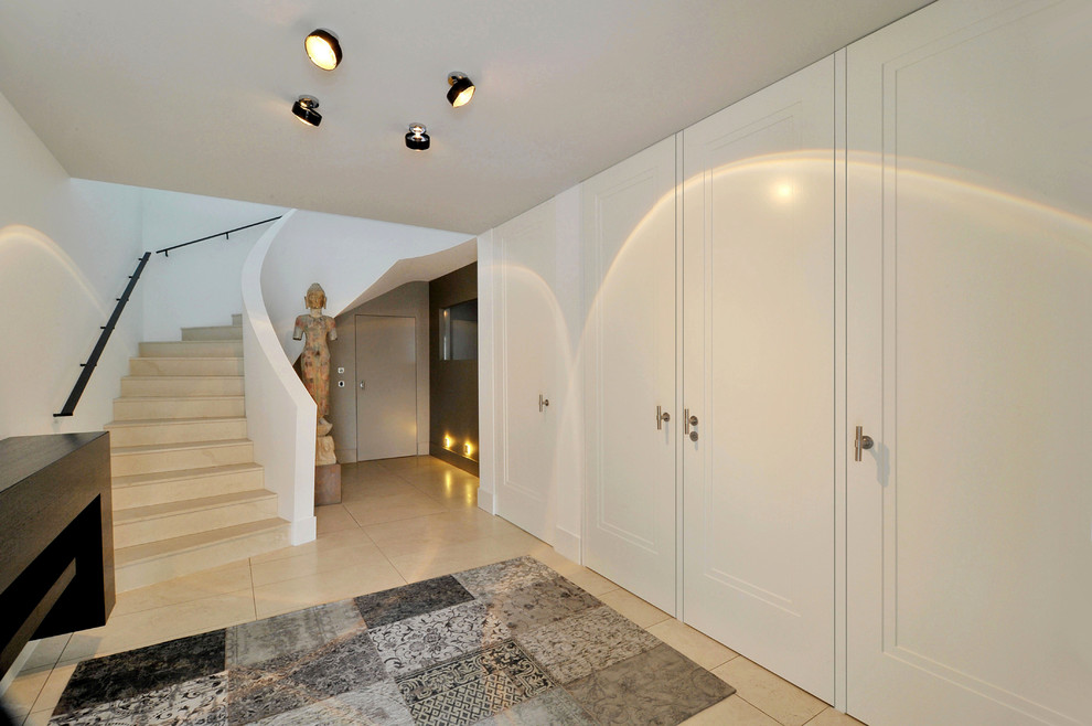 This is an example of a large asian hallway in Stuttgart with white walls and limestone floors.