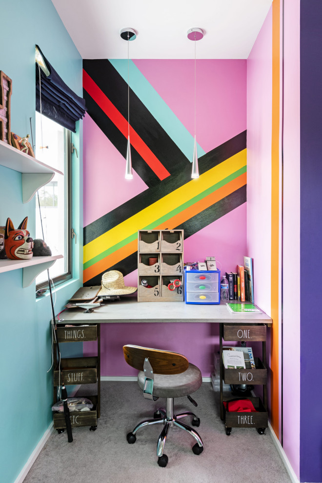 Cette image montre une chambre d'enfant design avec un bureau, un mur multicolore et un sol gris.