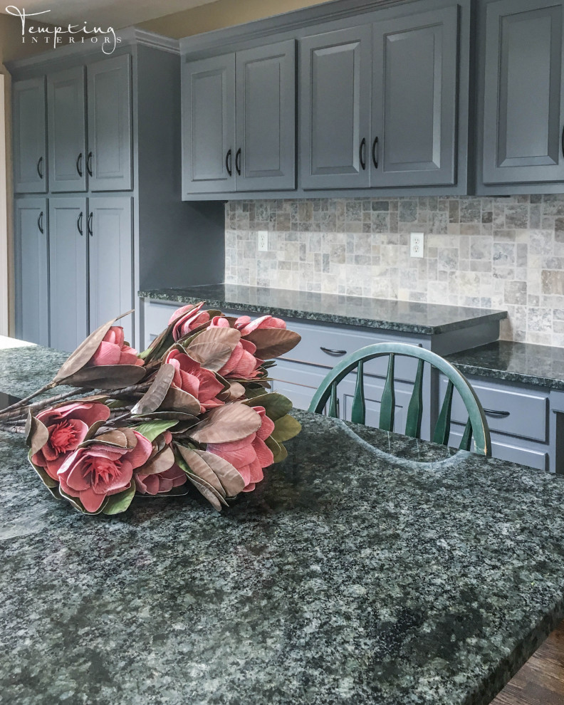 Inspiration for a rustic medium tone wood floor and brown floor kitchen remodel in Boston with a double-bowl sink, blue cabinets, granite countertops, gray backsplash, stone tile backsplash, stainless steel appliances, an island and black countertops