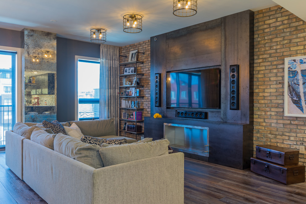 Photo of a large industrial open concept living room in New York with grey walls, dark hardwood floors, a ribbon fireplace, a metal fireplace surround, a built-in media wall and brown floor.