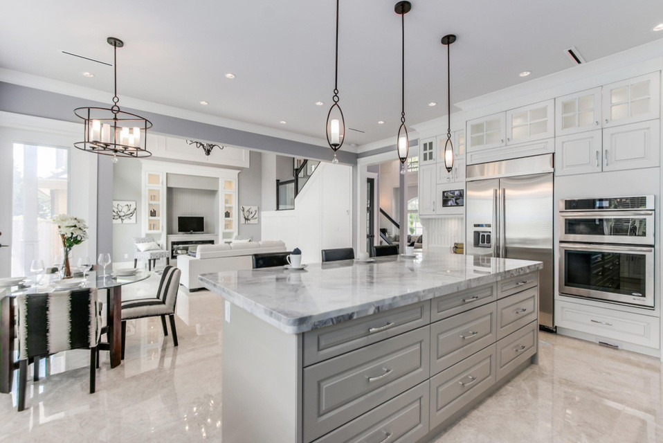 Example of a large transitional u-shaped porcelain tile open concept kitchen design in Vancouver with an undermount sink, raised-panel cabinets, white cabinets, marble countertops, gray backsplash, stone tile backsplash, stainless steel appliances and an island