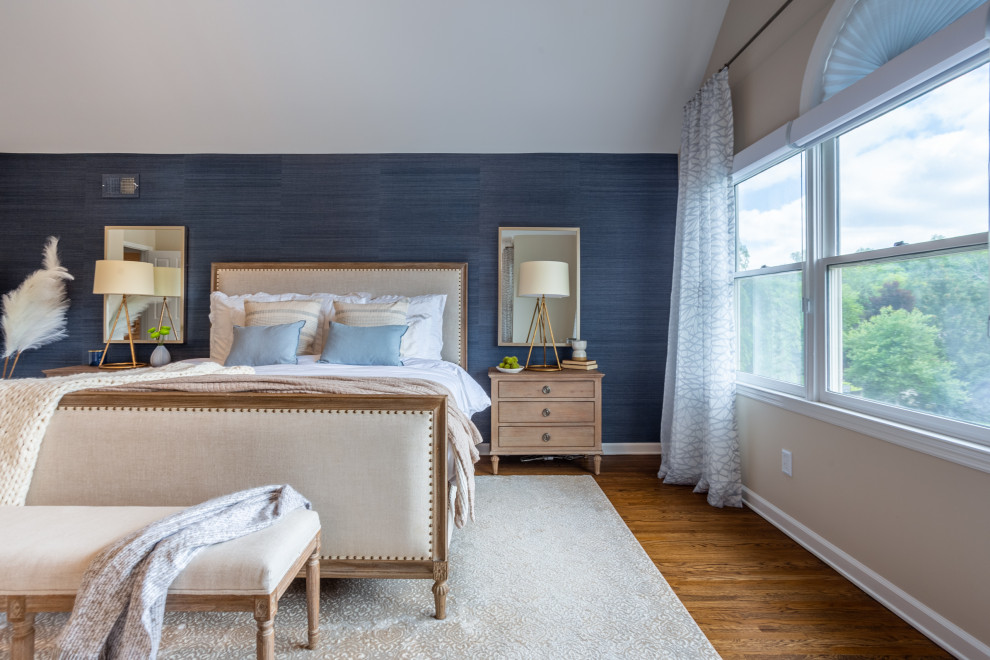 Photo of a large modern master bedroom in New York with blue walls, light hardwood floors, no fireplace, beige floor, vaulted and wallpaper.