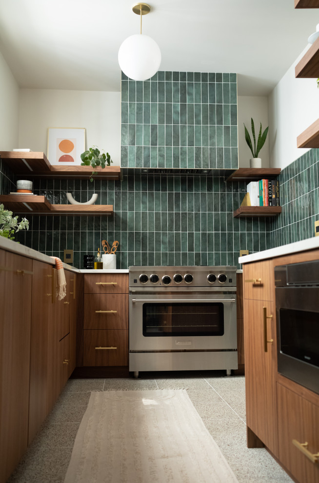シカゴにある高級な中くらいなミッドセンチュリースタイルのおしゃれなキッチン (フラットパネル扉のキャビネット、中間色木目調キャビネット、緑のキッチンパネル、パネルと同色の調理設備、アイランドなし、白いキッチンカウンター) の写真
