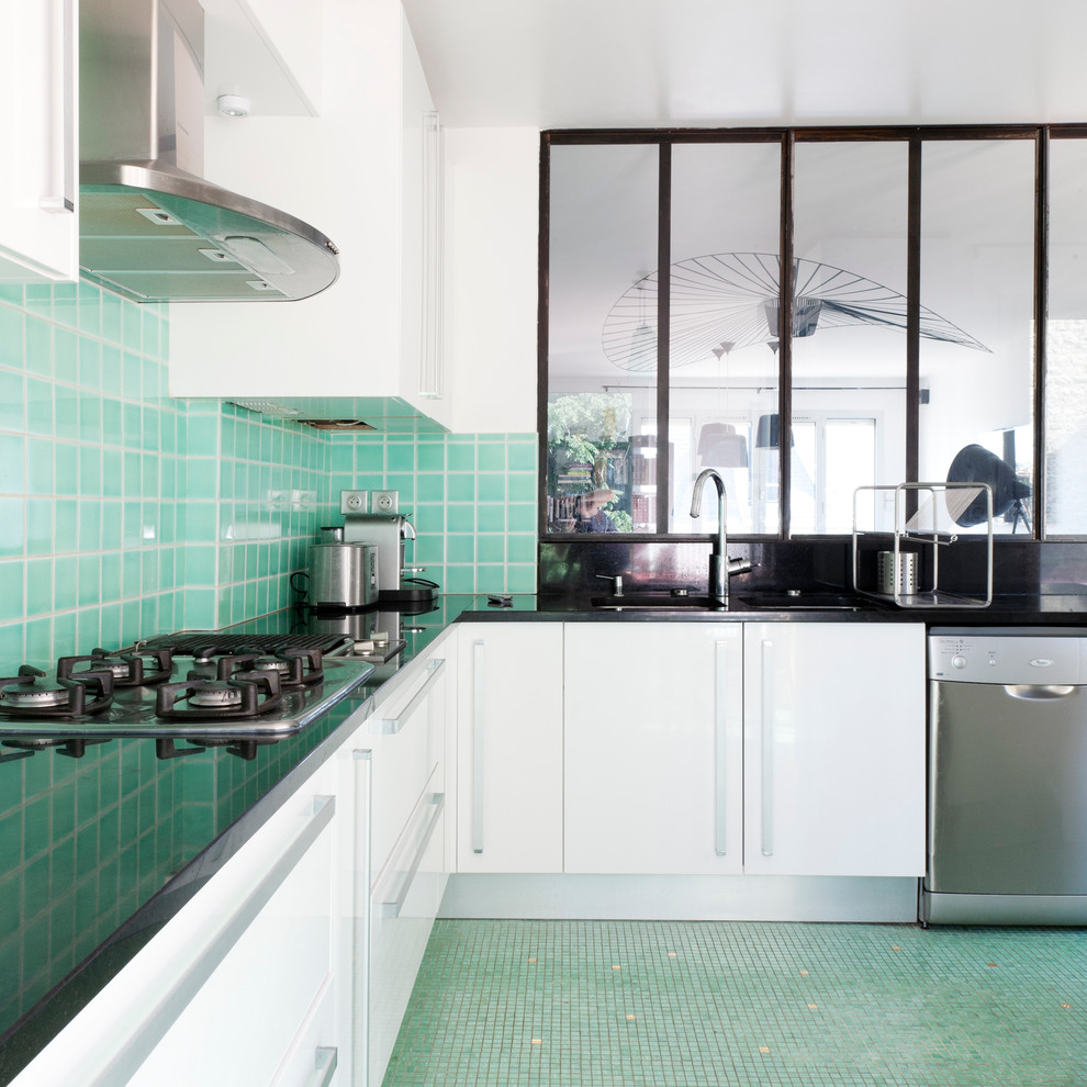 This is an example of a large industrial l-shaped separate kitchen in Paris with white cabinets, green splashback and no island.