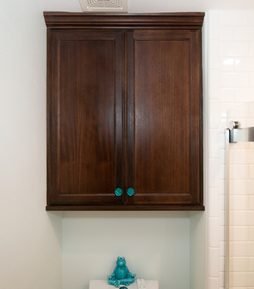 This is an example of a small eclectic kids bathroom in Other with recessed-panel cabinets, dark wood cabinets, an alcove tub, a two-piece toilet, blue tile, subway tile, blue walls, vinyl floors, an undermount sink, engineered quartz benchtops and brown floor.