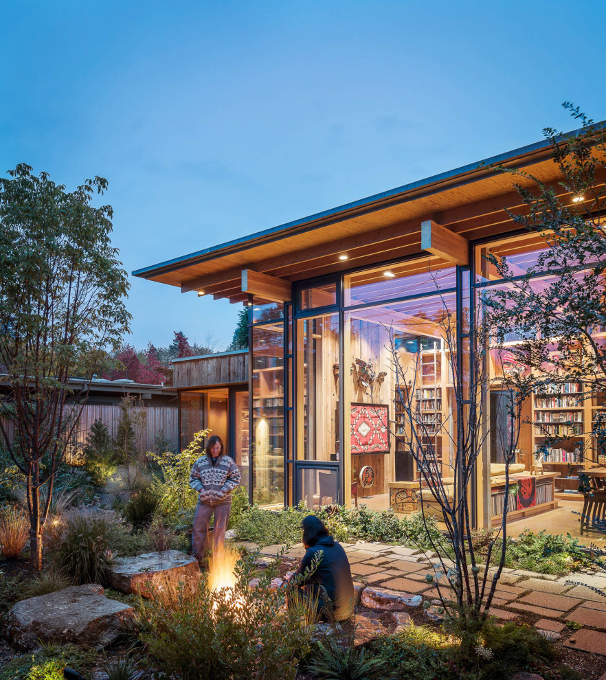 Contemporary one-storey glass house exterior in Seattle with a green roof.