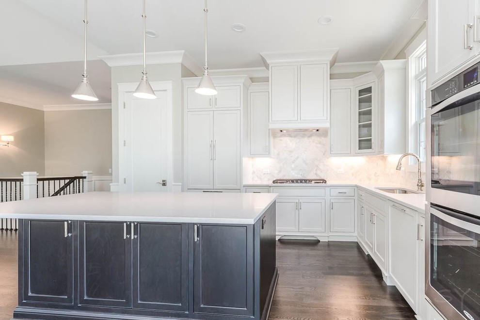 Mid-sized transitional l-shaped dark wood floor eat-in kitchen photo in Chicago with shaker cabinets, white cabinets, gray backsplash, stone tile backsplash, stainless steel appliances and an island