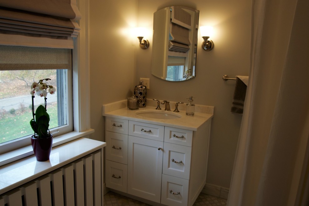 Tub/shower combo - small transitional gray tile, white tile and subway tile mosaic tile floor tub/shower combo idea with recessed-panel cabinets, a two-piece toilet, marble countertops, an undermount sink, white cabinets and white walls