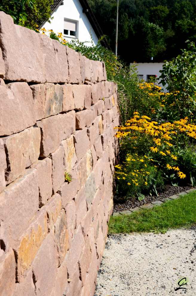 Immagine di un'aiuola country esposta in pieno sole di medie dimensioni e nel cortile laterale in estate con pavimentazioni in pietra naturale