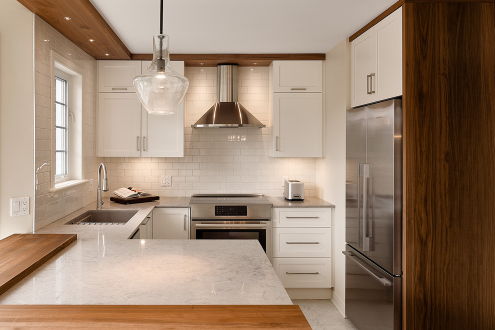 Inspiration for a contemporary l-shaped separate kitchen in Other with an undermount sink, shaker cabinets, white cabinets, white splashback, stainless steel appliances, subway tile splashback, a peninsula and grey floor.