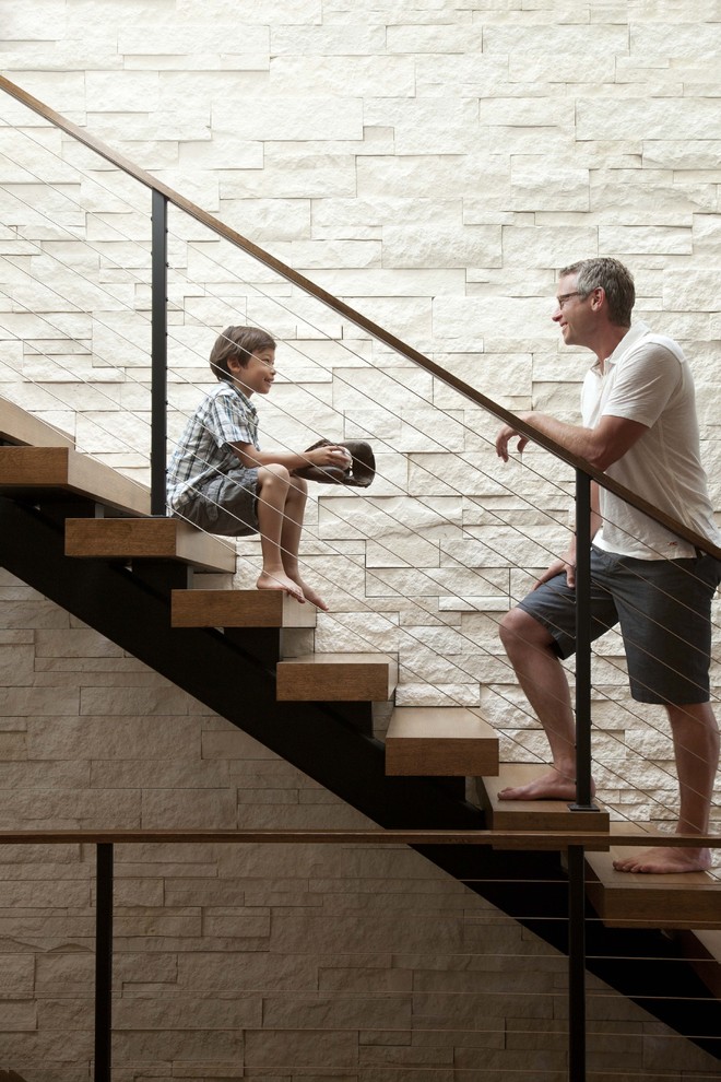 Contemporary wood staircase in Minneapolis with cable railing and open risers.