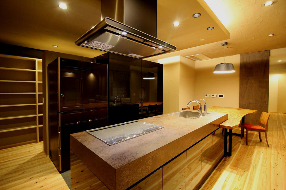 This is an example of an asian kitchen in Other with a single-bowl sink, flat-panel cabinets, medium hardwood floors, with island and brown floor.
