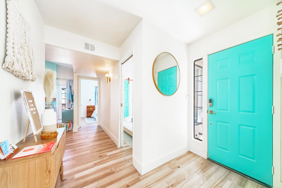 フェニックスにあるお手頃価格の中くらいなコンテンポラリースタイルのおしゃれな玄関ドア (白い壁、磁器タイルの床、青いドア、ベージュの床、三角天井) の写真