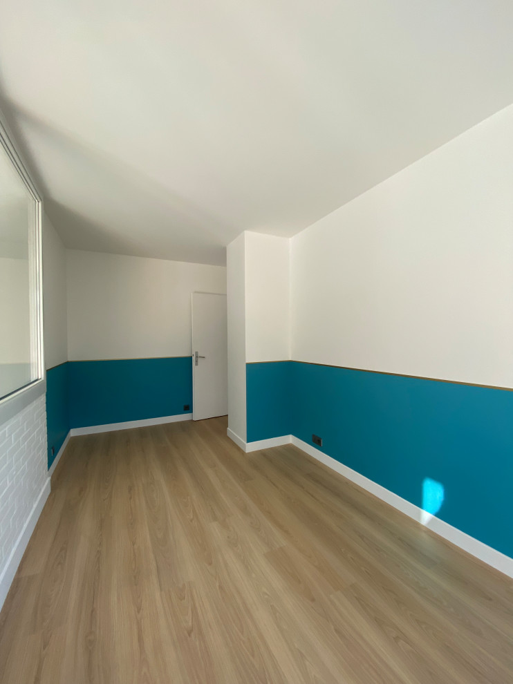 Esempio di una cameretta per bambini da 4 a 10 anni moderna di medie dimensioni con pavimento in laminato, pavimento beige e pareti blu