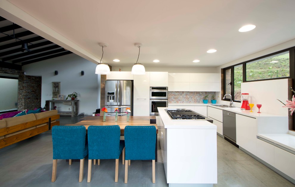 Design ideas for a contemporary l-shaped open plan kitchen in Miami with a double-bowl sink, flat-panel cabinets, white cabinets, multi-coloured splashback, stainless steel appliances and with island.