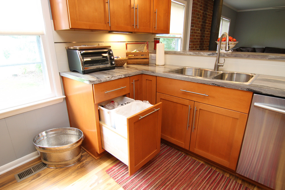Large transitional u-shaped medium tone wood floor eat-in kitchen photo with a drop-in sink, recessed-panel cabinets, medium tone wood cabinets, laminate countertops, white backsplash, ceramic backsplash, stainless steel appliances and a peninsula