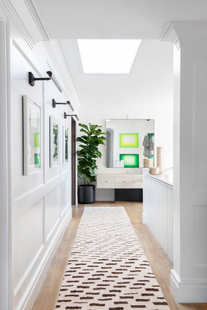 Inspiration for a large modern hallway in New York with white walls, light hardwood floors and beige floor.