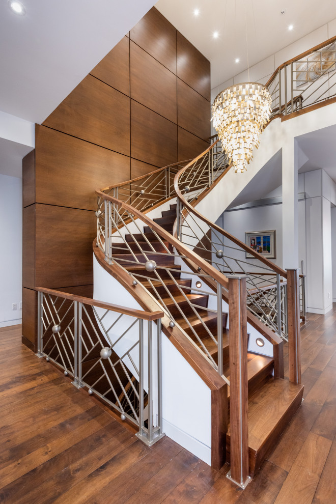Inspiration for an expansive transitional wood spiral staircase in Toronto with wood risers, mixed railing and wood walls.