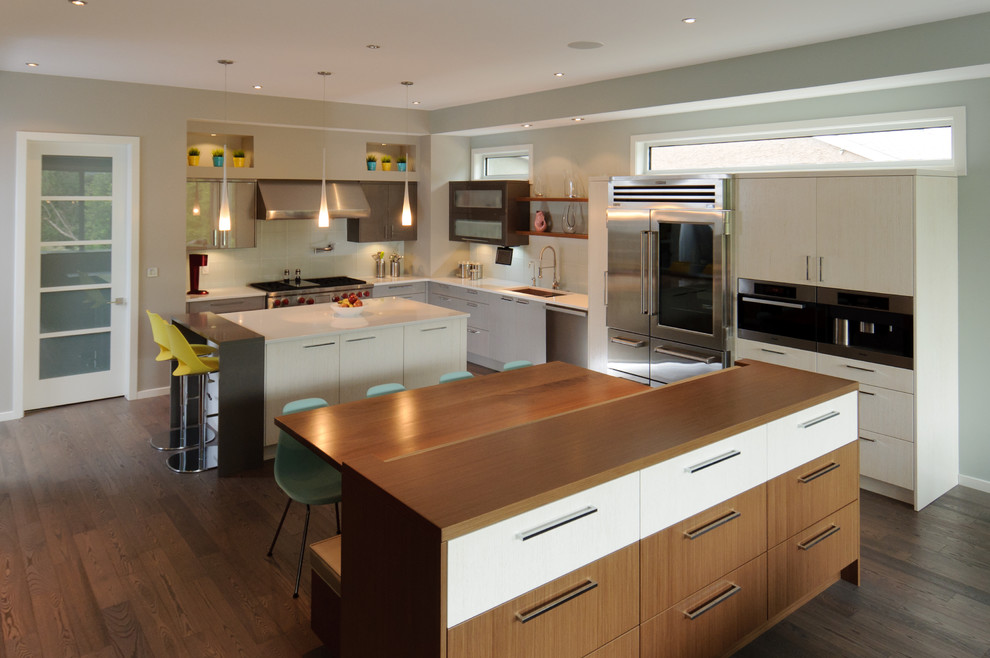 Photo of a large contemporary l-shaped eat-in kitchen in Calgary with an undermount sink, flat-panel cabinets, quartz benchtops, glass tile splashback, stainless steel appliances, dark hardwood floors and with island.