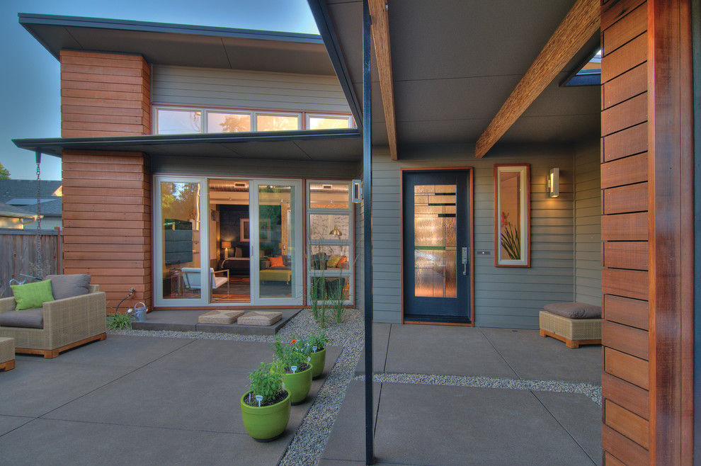Inspiration for a small transitional courtyard concrete drought-tolerant patio remodel with a roof extension
