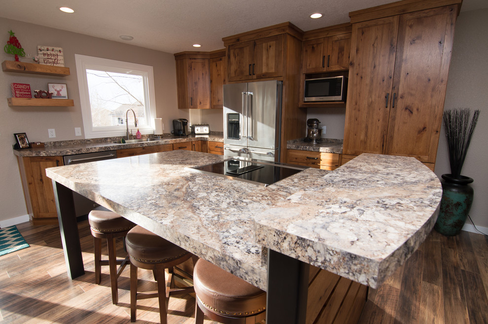 Example of a mid-sized mountain style l-shaped medium tone wood floor and brown floor eat-in kitchen design in Denver with an undermount sink, shaker cabinets, medium tone wood cabinets, quartz countertops, black appliances, an island and multicolored countertops