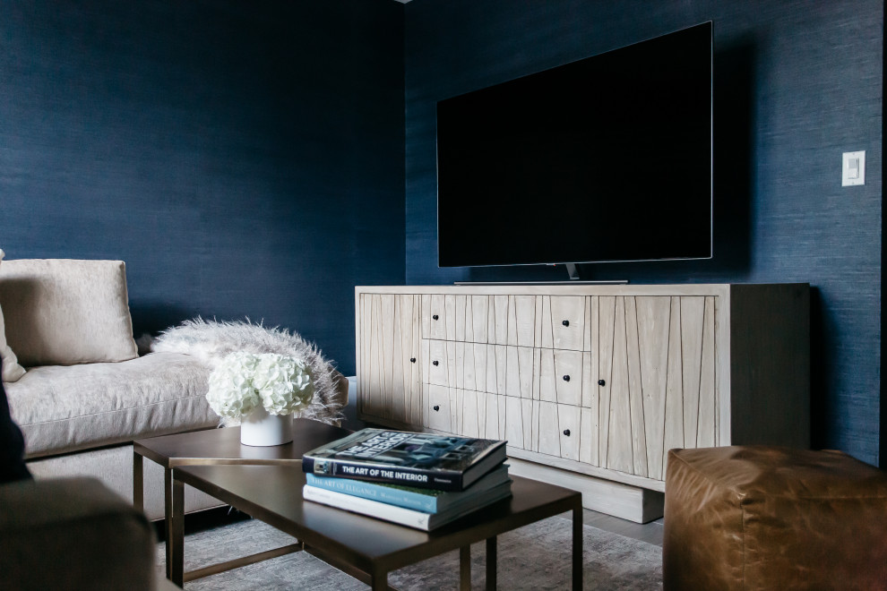 Example of a small transitional look-out medium tone wood floor, brown floor and wallpaper basement design in DC Metro with a home theater and blue walls