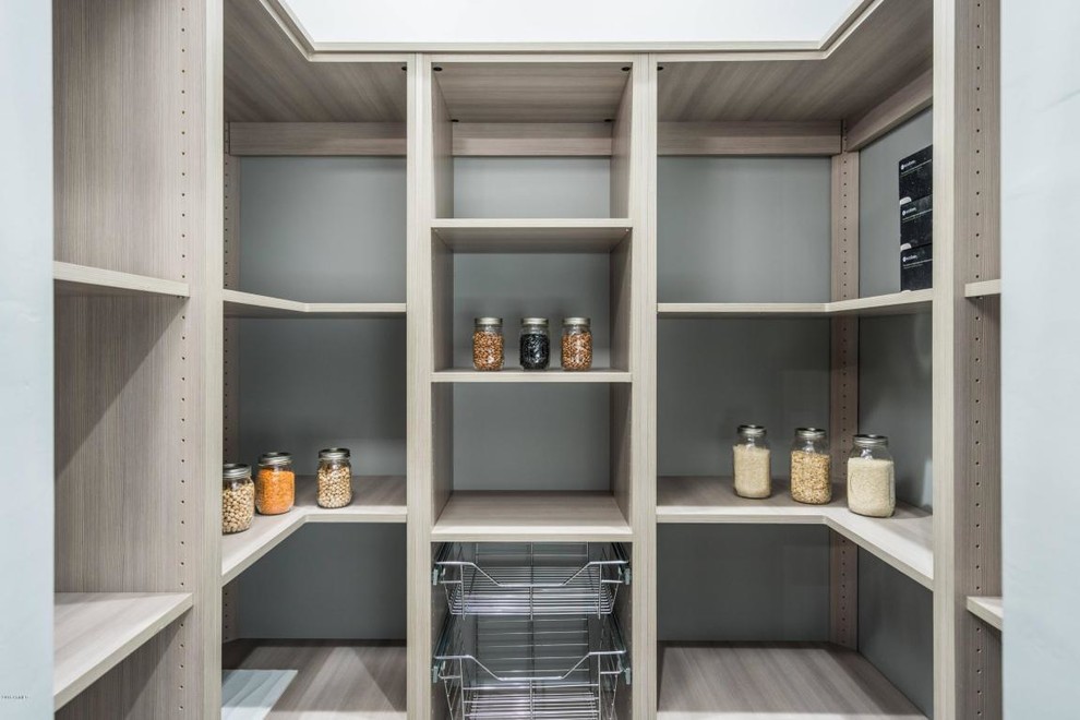 This is an example of an expansive modern galley kitchen pantry in Phoenix with a farmhouse sink, flat-panel cabinets, light wood cabinets, granite benchtops, white splashback, marble splashback, stainless steel appliances, porcelain floors, with island and grey floor.