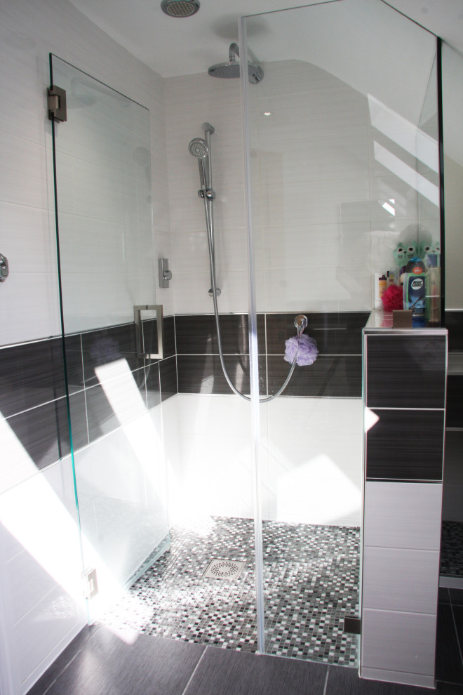 Inredning av ett klassiskt mellanstort vit vitt en-suite badrum, med grå skåp, en kantlös dusch, en toalettstol med separat cisternkåpa, flerfärgad kakel, keramikplattor, vita väggar, klinkergolv i porslin, ett undermonterad handfat, kaklad bänkskiva, grått golv och dusch med gångjärnsdörr