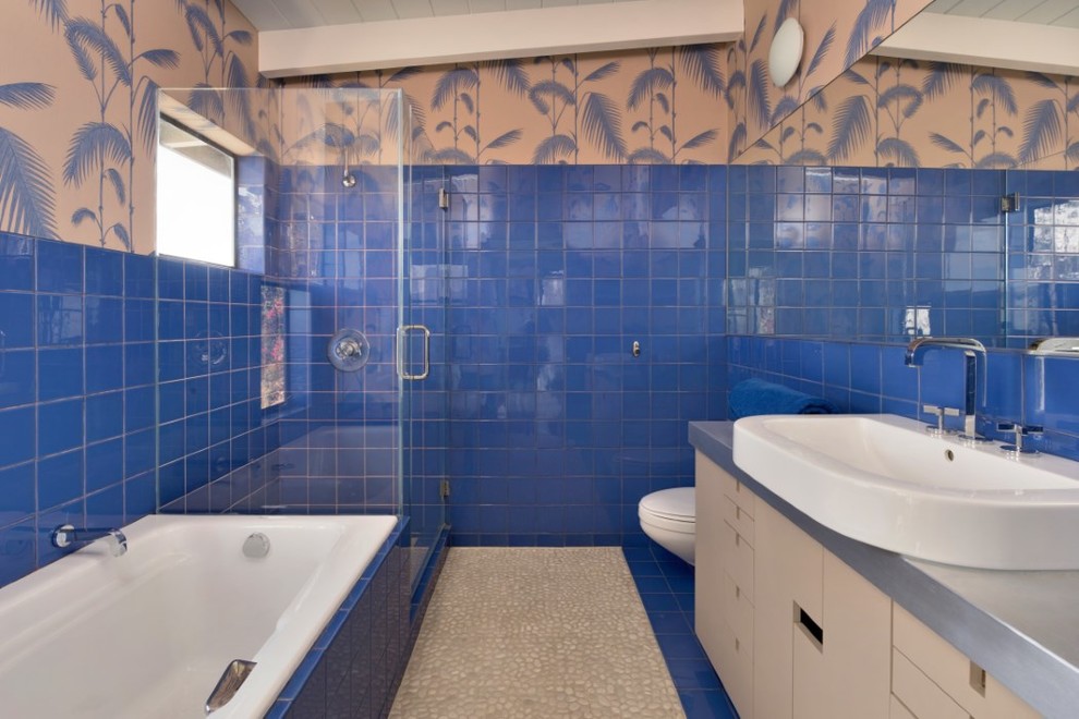 Inspiration for an eclectic master bathroom in Los Angeles with flat-panel cabinets, a drop-in tub, an open shower, blue tile, ceramic tile, pebble tile floors, a vessel sink and a hinged shower door.