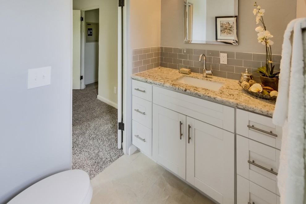 This is an example of an arts and crafts bathroom in San Diego with shaker cabinets, white cabinets and granite benchtops.