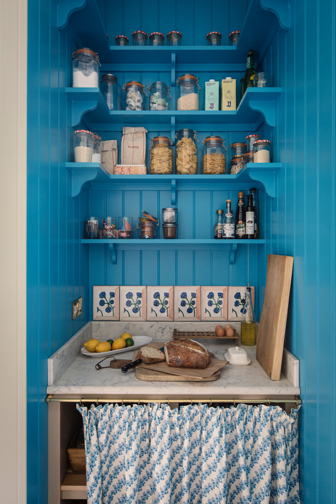Medium sized classic single-wall kitchen/diner in London with a belfast sink, shaker cabinets, beige cabinets, quartz worktops, beige splashback, black appliances, an island, brown floors and grey worktops.