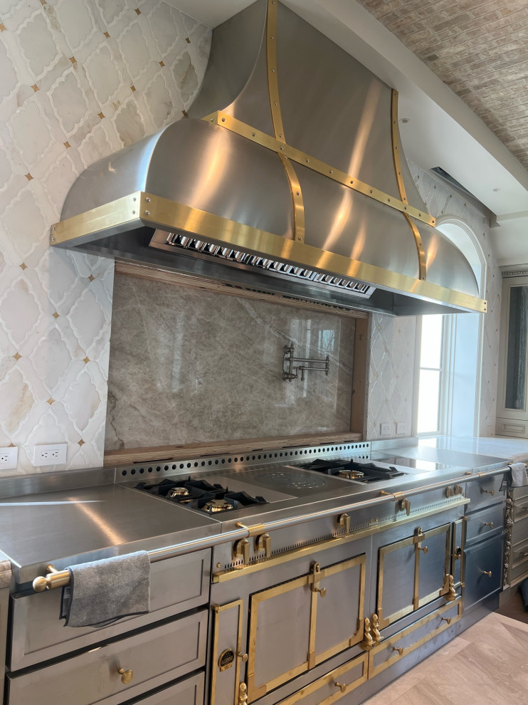 Example of a large u-shaped eat-in kitchen design in Phoenix with paneled appliances and an island