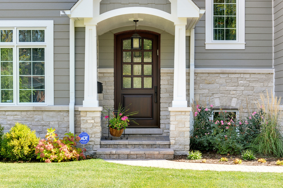 Example of a transitional single front door design in Chicago with a dark wood front door