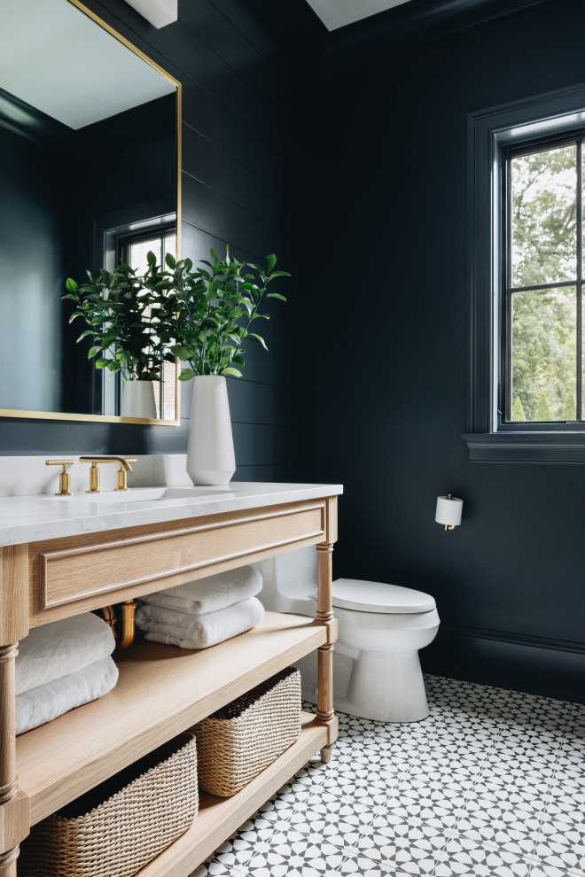 Inredning av ett klassiskt stort flerfärgad flerfärgat toalett, med öppna hyllor, skåp i ljust trä, en toalettstol med hel cisternkåpa, blå väggar, ett nedsänkt handfat och flerfärgat golv