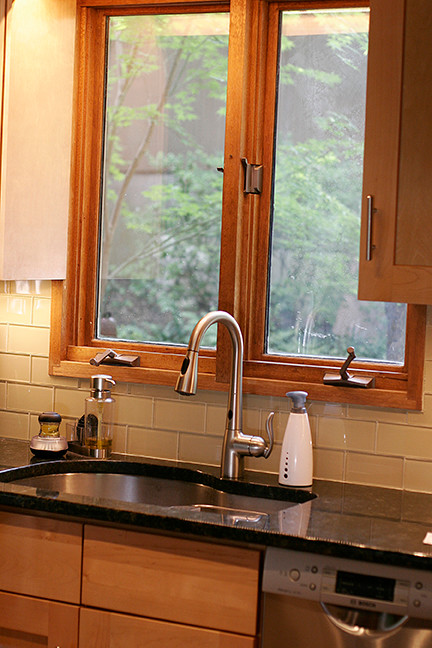 Small transitional l-shaped porcelain tile eat-in kitchen photo with shaker cabinets, light wood cabinets, granite countertops, beige backsplash, glass tile backsplash, stainless steel appliances and a peninsula