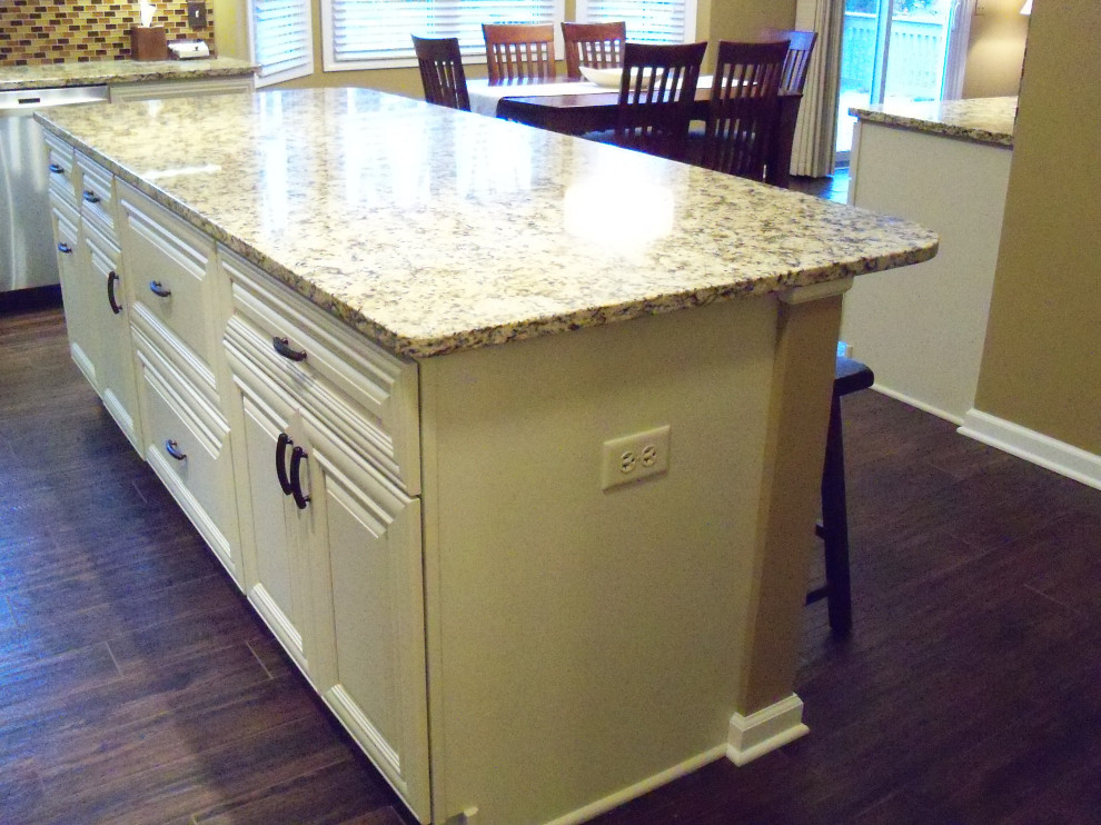 Open concept kitchen - transitional ceramic tile and brown floor open concept kitchen idea in Cleveland with raised-panel cabinets, white cabinets, granite countertops, brown backsplash, glass tile backsplash, an island and beige countertops