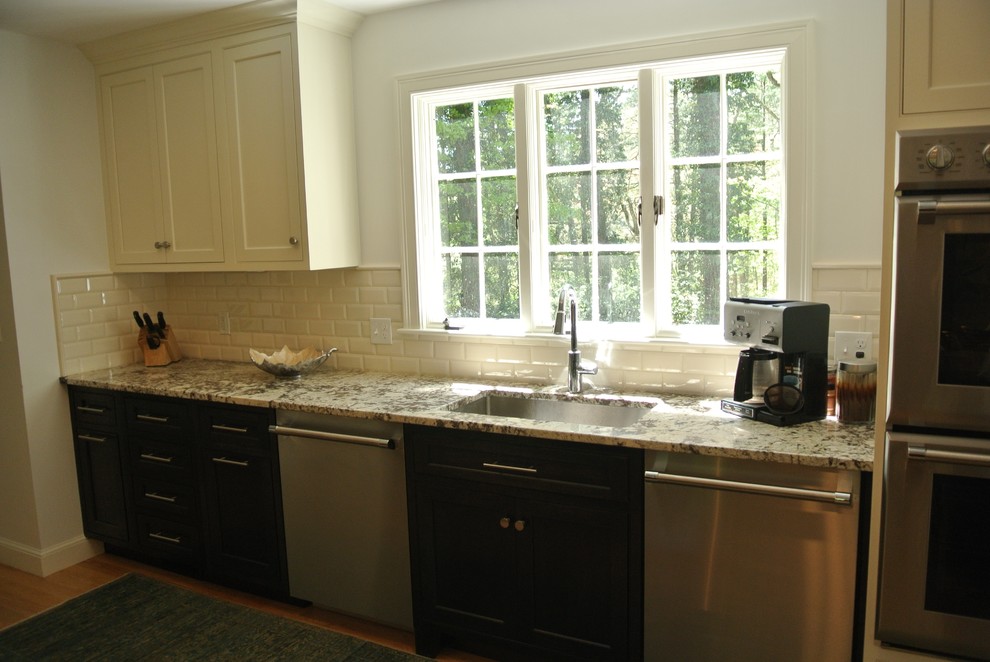 Example of a transitional light wood floor eat-in kitchen design in Boston with an undermount sink, shaker cabinets, granite countertops, white backsplash, subway tile backsplash, stainless steel appliances and an island