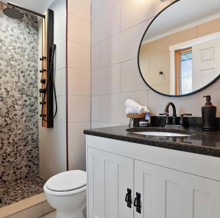 Mid-sized modern 3/4 bathroom in Minneapolis with flat-panel cabinets, white cabinets, an open shower, gray tile, mosaic tile, beige walls, ceramic floors, a drop-in sink, granite benchtops, beige floor, an open shower, black benchtops, a single vanity and a freestanding vanity.